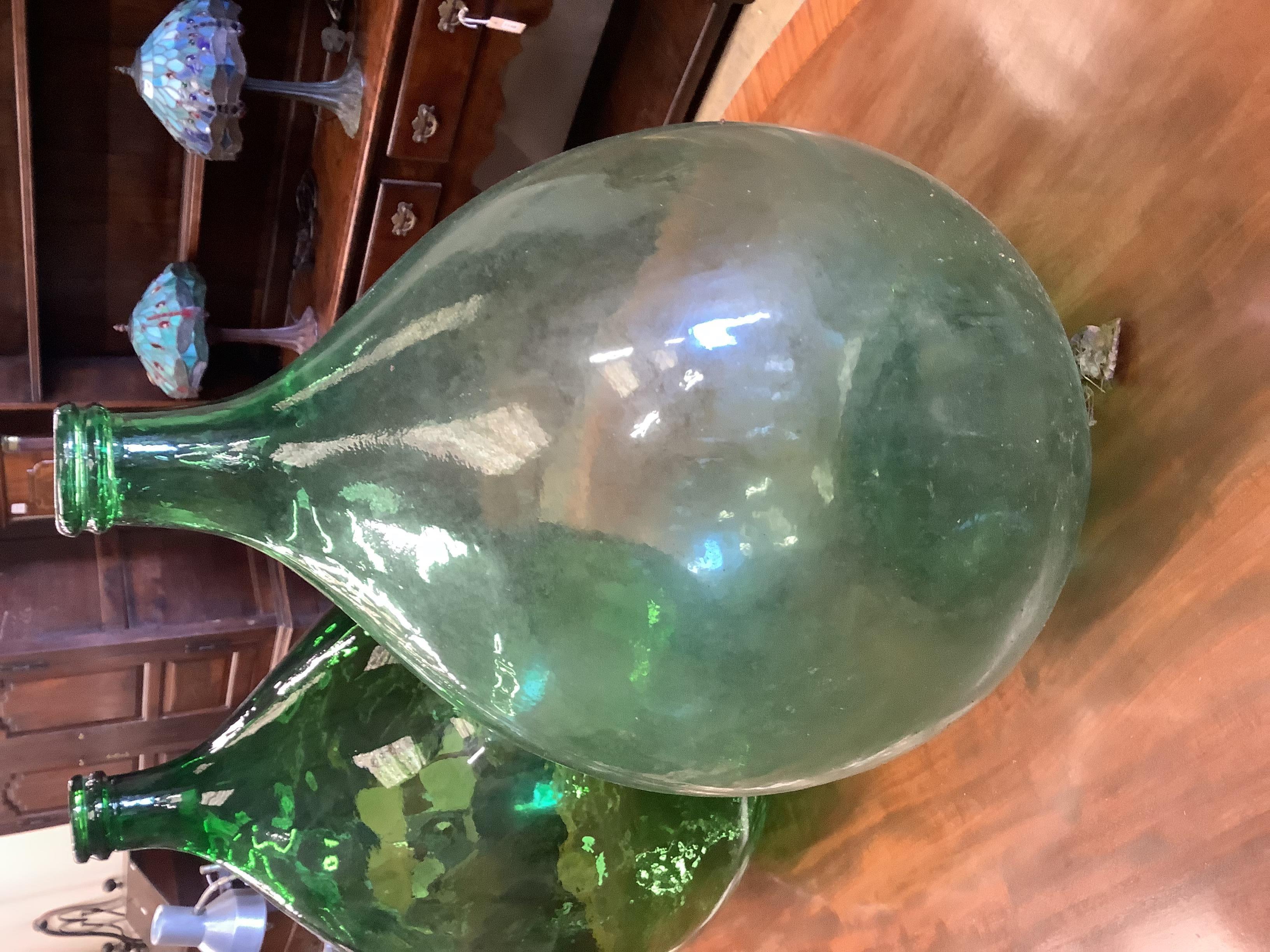 A pair of green glass carboys, height 62cm